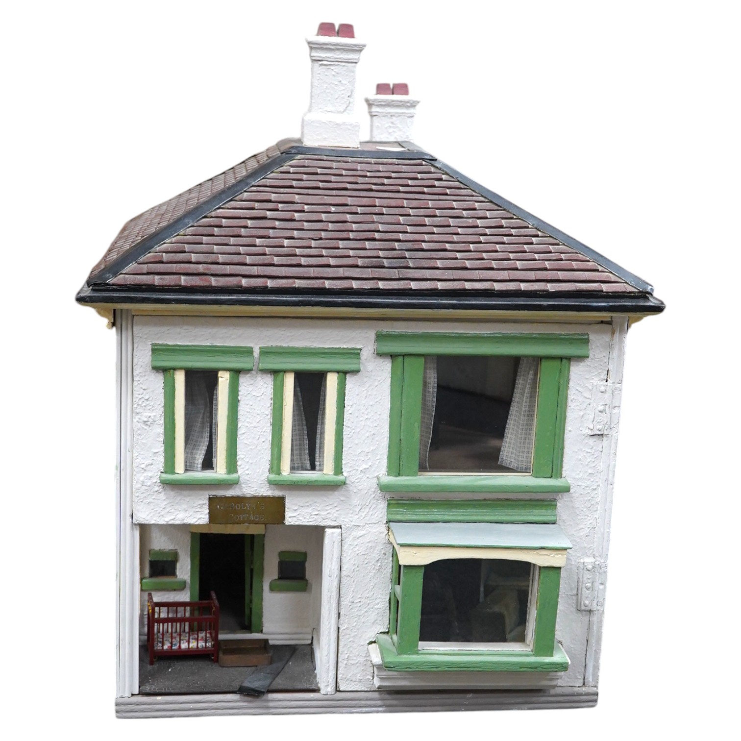 A mid-20th century green and white plywood doll's house, with a pyramid hip tiled roof, together with some plywood furniture including furniture from the Pit-A-Pat Series, height 67cm, width 54cm, depth 54cm. Condition -